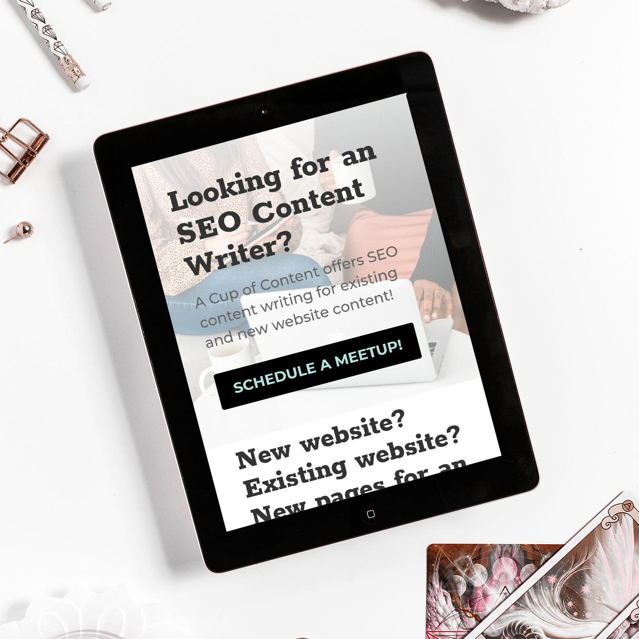 smart tablet on a white table with paperclips surrounding it showing seo content writing editing services by a cup of content